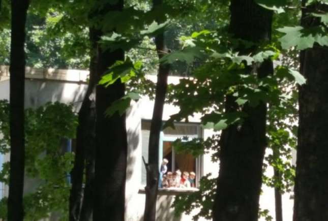 Copiii unei grădiniţe din Chișinău, surprinși pe pervazul unui geam deschis după ce au rămas singuri în grupă